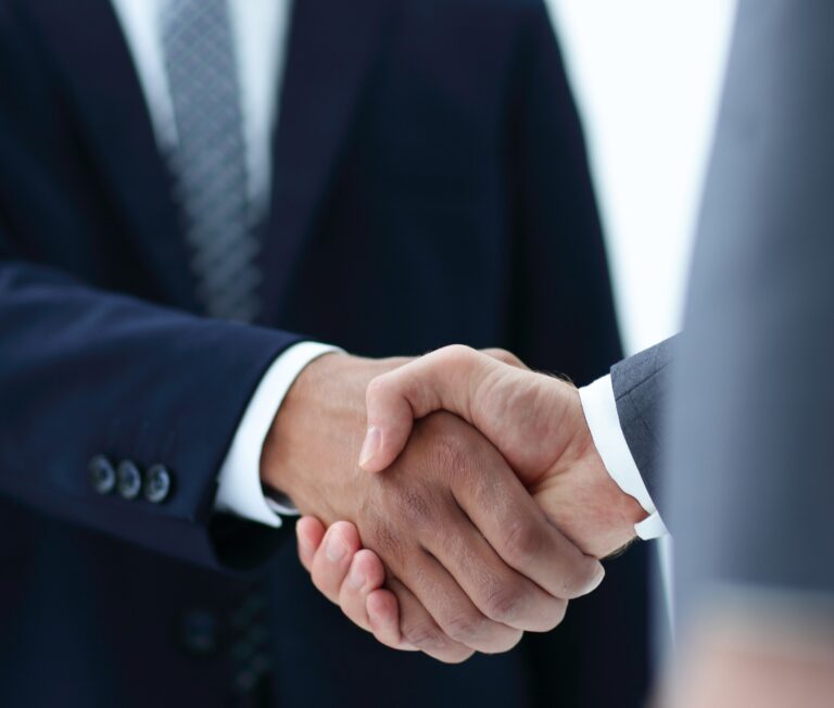 Two suited persons shaking hands. Possibly lawyers.